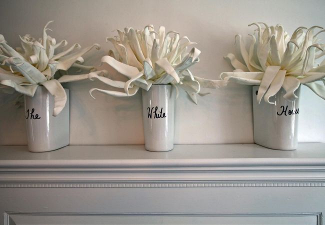Fireplace mantle with 3 vases with the words 